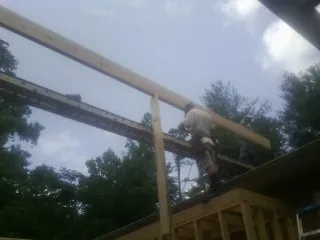 Carpenter setting a ridge beam over a new addition frame — Ice Dam Removal by Roofing Brothers in New Providence