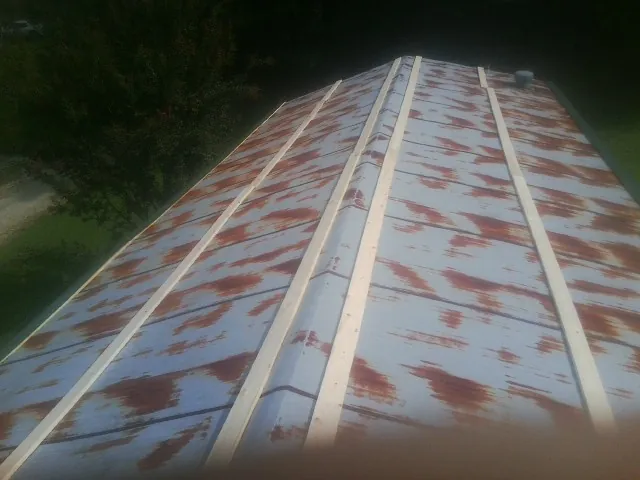 Rusted metal roof panels with new wood purlins before replacement — Storm Damage Roof Repair in New Providence by Roofing Brothers