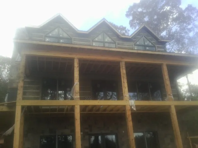 Dormers and porch framing on a large log home under construction — Roof Coating work by our crew in New Providence